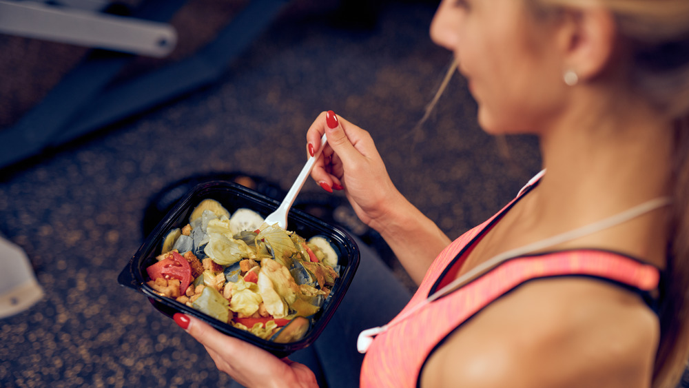 woman in workout gear eating