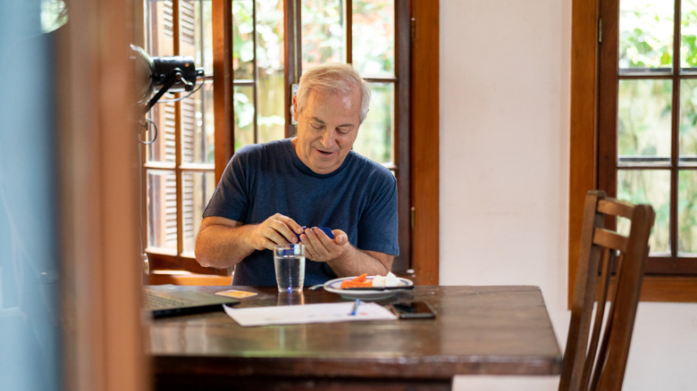 man taking pill or vitamin with breakfast