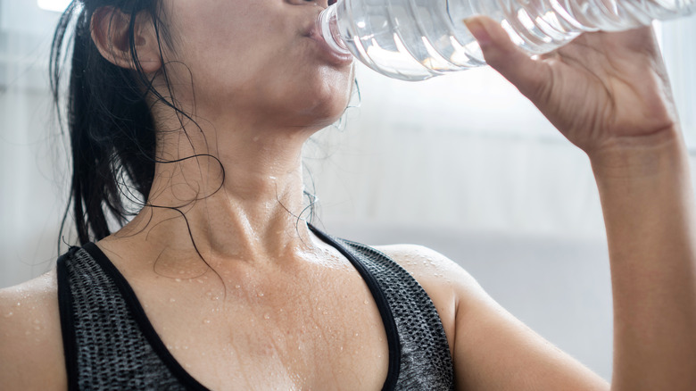 Sweaty woman drinking water
