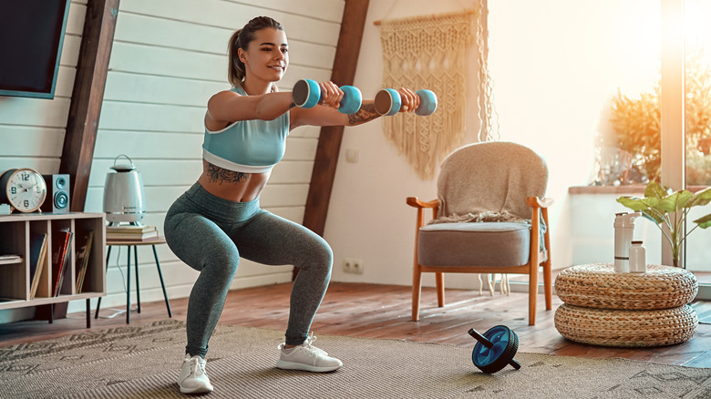 Fit woman doing squats at home