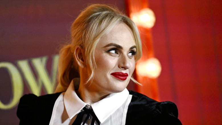 Rebel Wilson smiles as she poses at a celebrity event