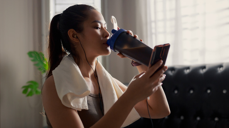 Fit woman drinking a pre-workout shake