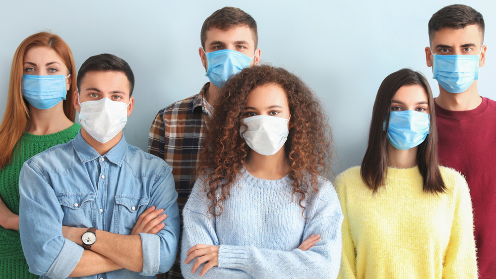 People with face masks looking at camera
