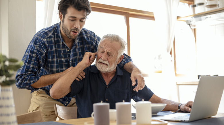 A man with dementia at home refusing help from his male caregiver