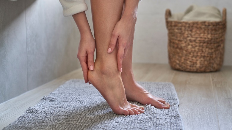 woman checking her feet in the bathroom