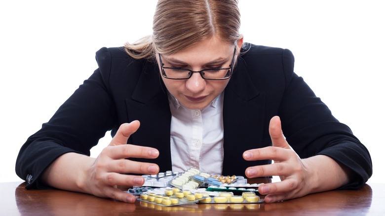 woman at table with pill packets