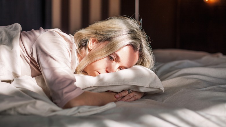 tired woman laying in bed