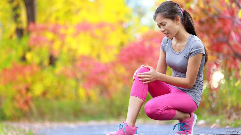 woman runner holding her knee