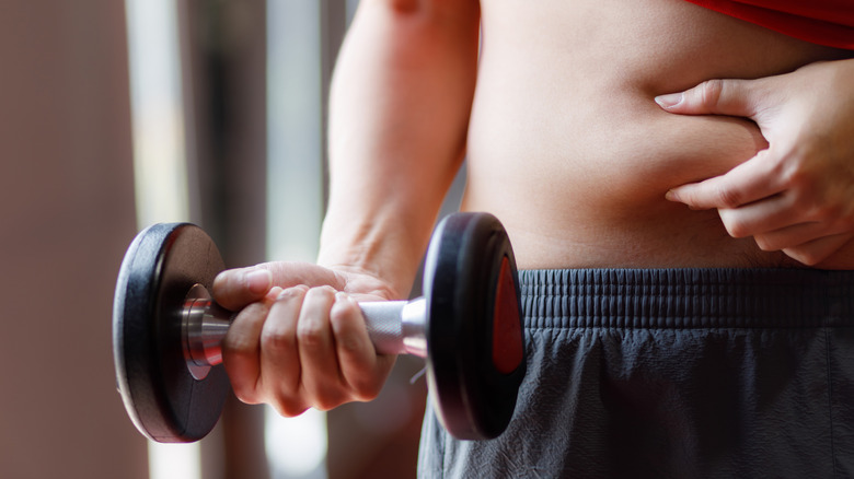 person pinching belly fat