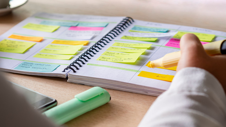 Person planning calendar with highlighters