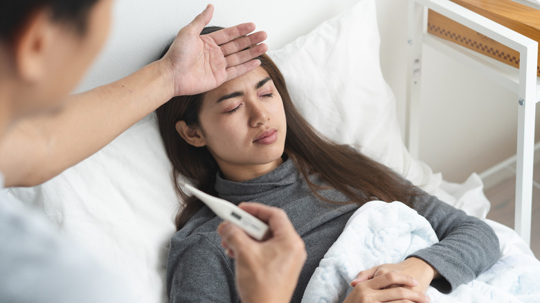 Woman with fever in bed