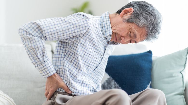 Man holding lower back in pain