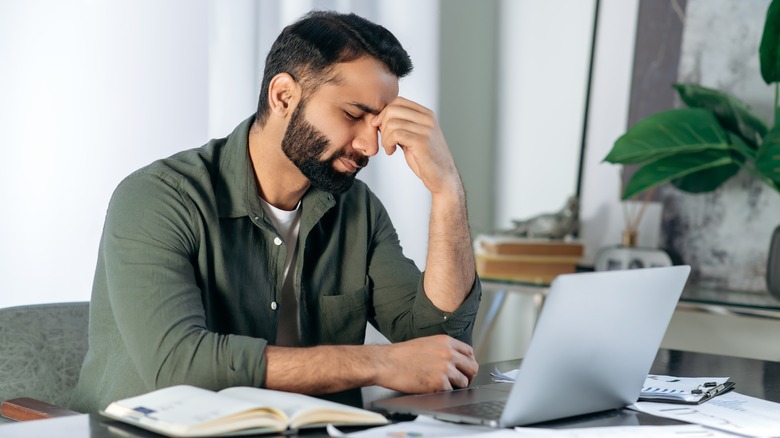 man sitting and holding head