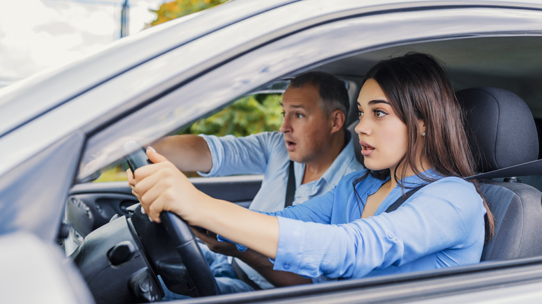 young woman driving with her dad