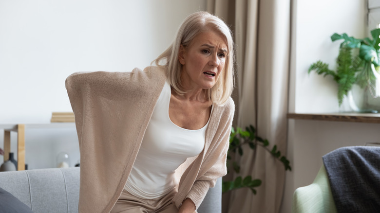 middle aged person holding sore hip