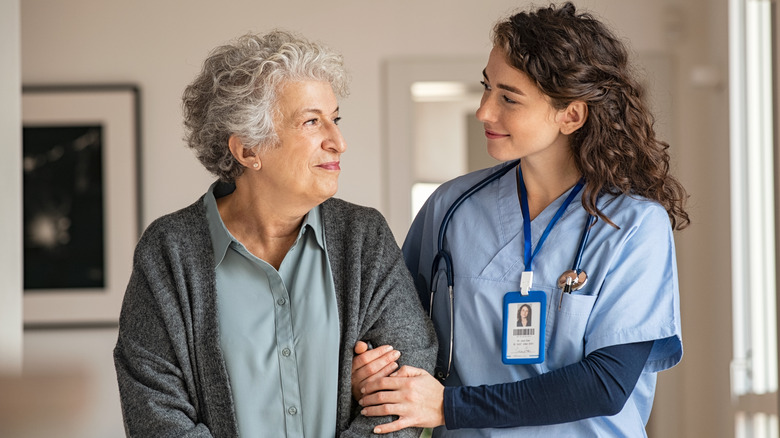 health care worker helping a senior woman walk