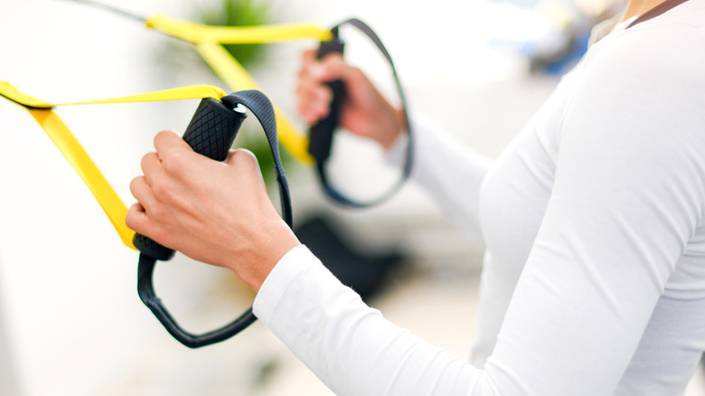 Woman working out with suspension trainer