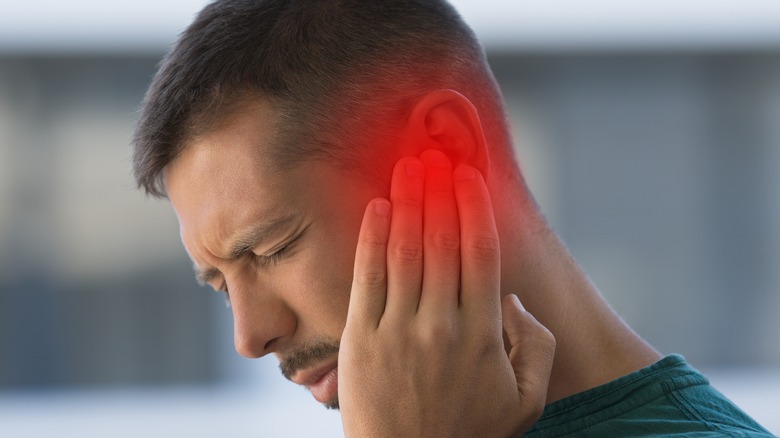 man holding painful ear