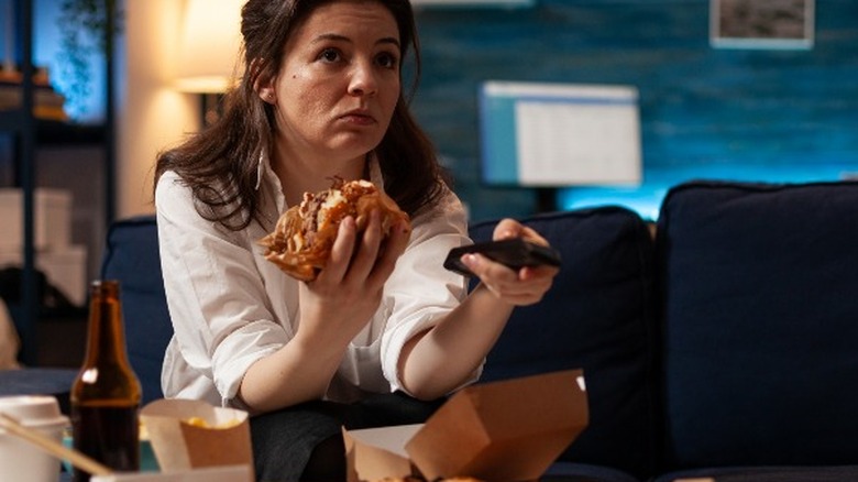 Woman eating and watching TV
