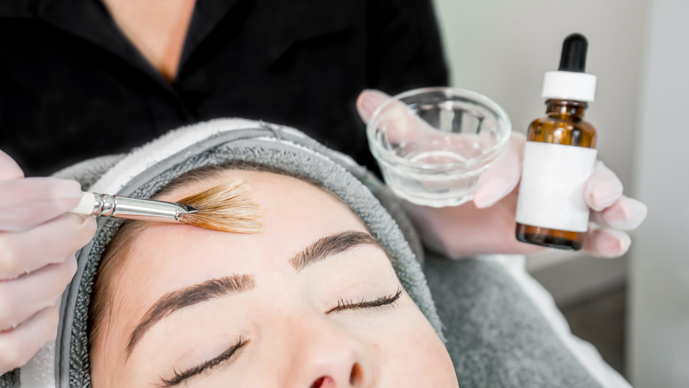 Aesthetician applying chemical peel to face