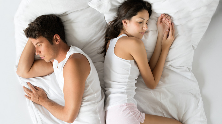 Couple sleeping on same bed