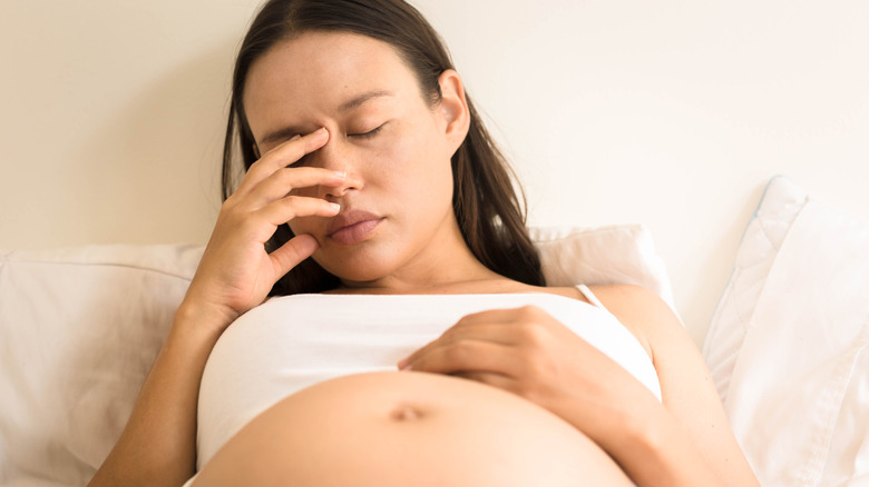 Exhausted pregnant woman in bed 