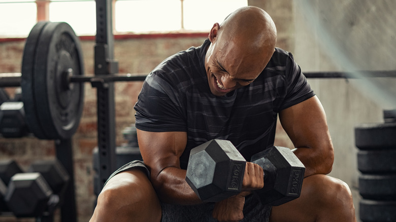 man lifting a heavy dumbbell