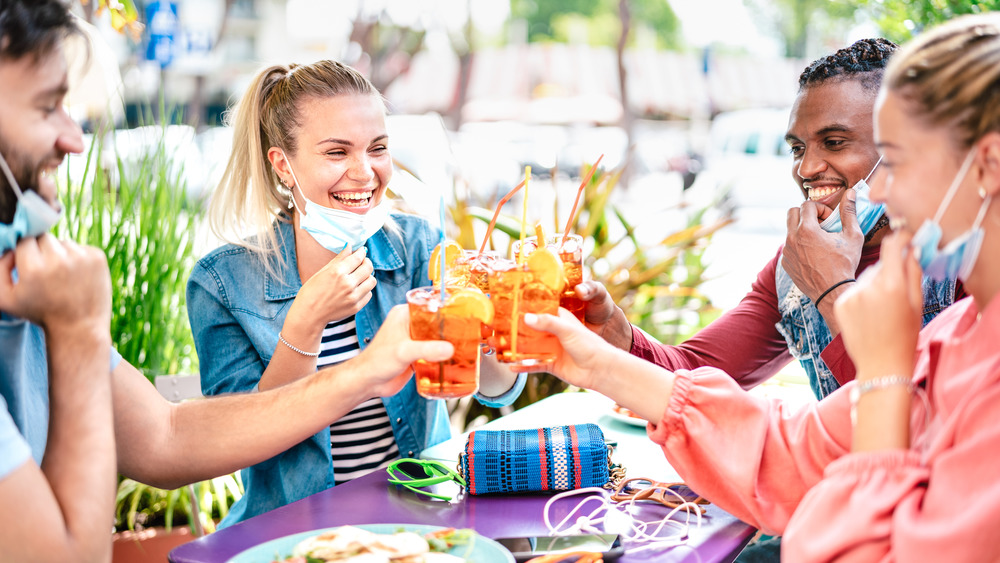 Four people with face masks down dine outside