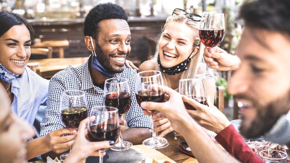 Group of people socialize with face masks down