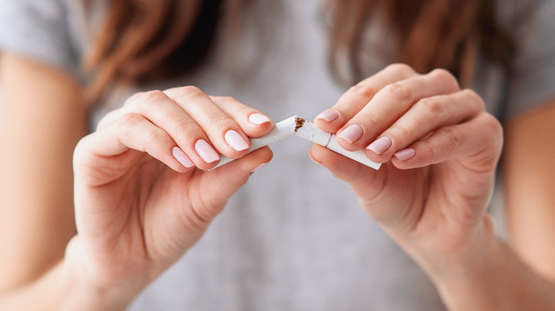 Woman breaking a cigarette in half