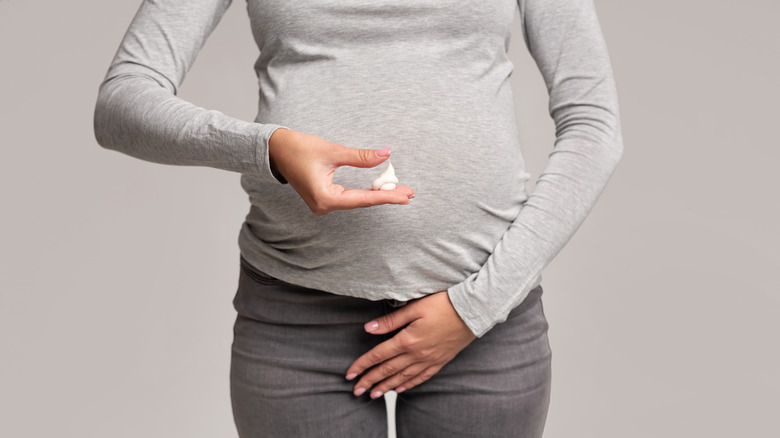 pregnant person holding cream