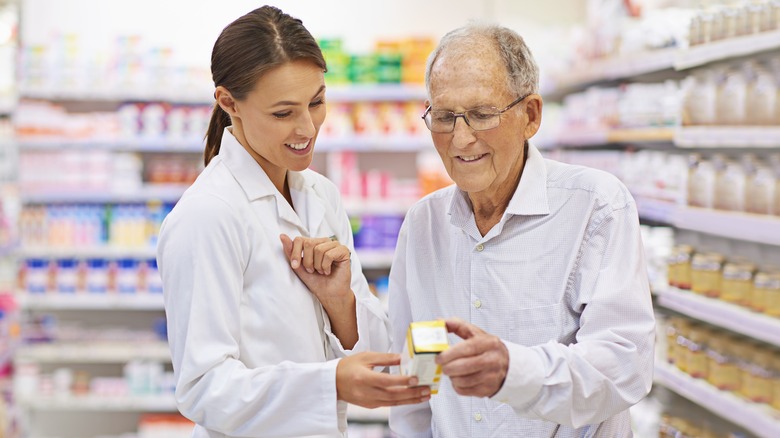 Pharmacist helping man choose medication