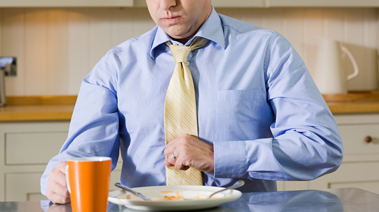 Office man with indigestion during breakfast