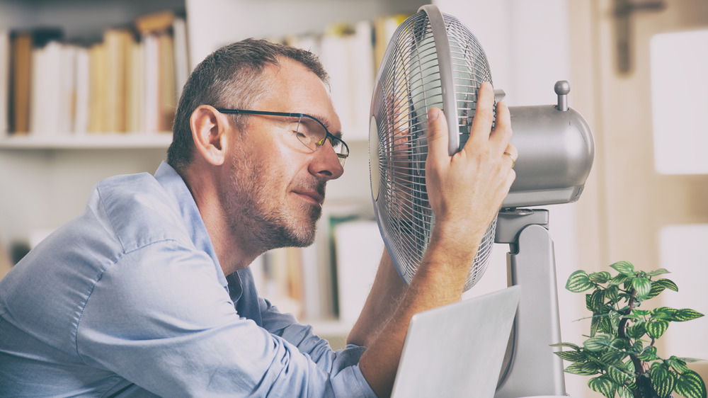man sweating, fan