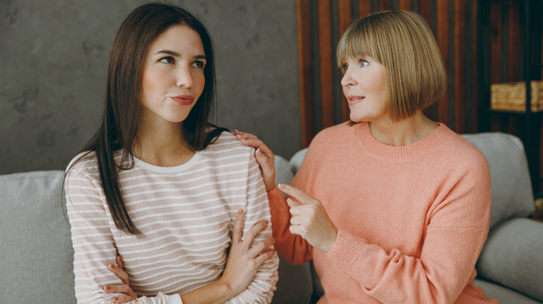 Young woman looking smug beside mature woman