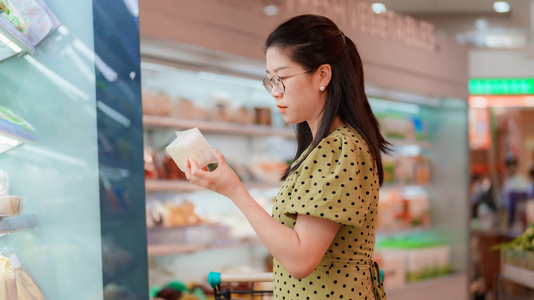 woman buying tofu in grocery