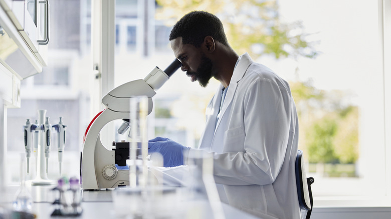 A researcher looking through a microscope