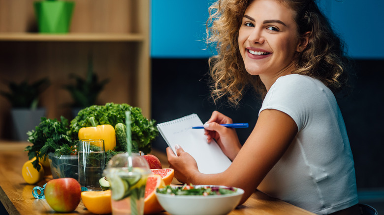 smiling woman beside vegetables