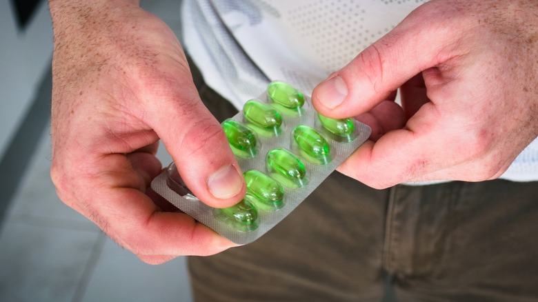 Man holding blister pack of medication