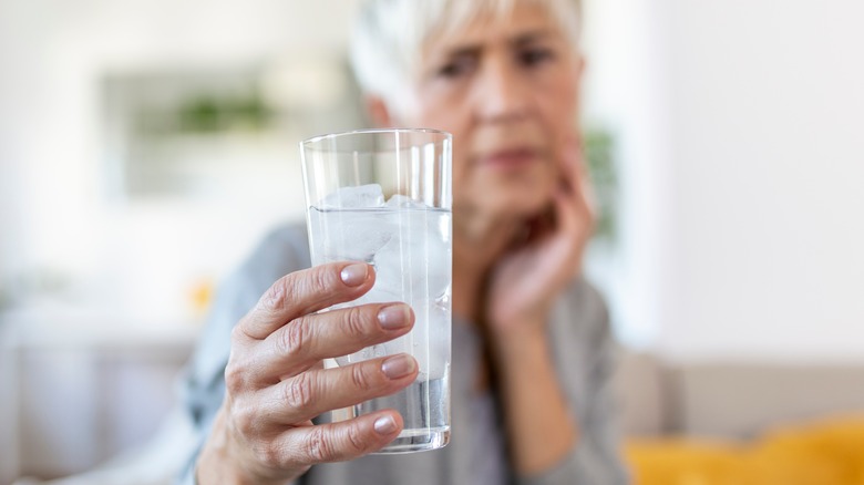 Woman holding glass of ice water