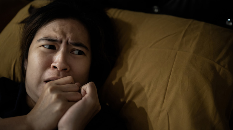 Nervous woman in bed