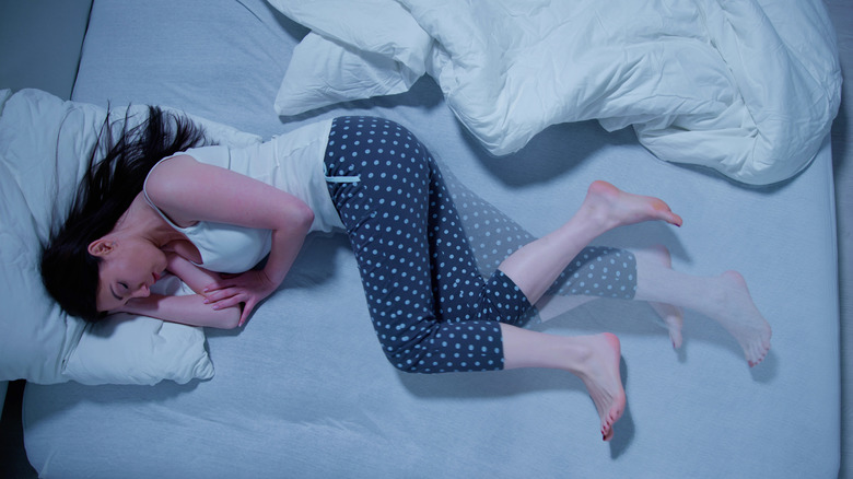 A woman with restless legs lying in bed