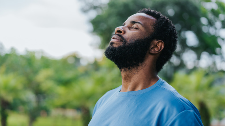 man enjoying a deep breath while outdoors