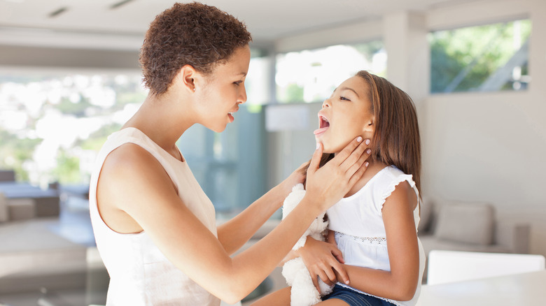 a little boy with strep throat has his throat checked