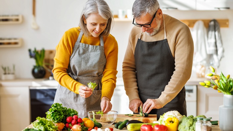 middle-aged couple fixing a healthy dinner