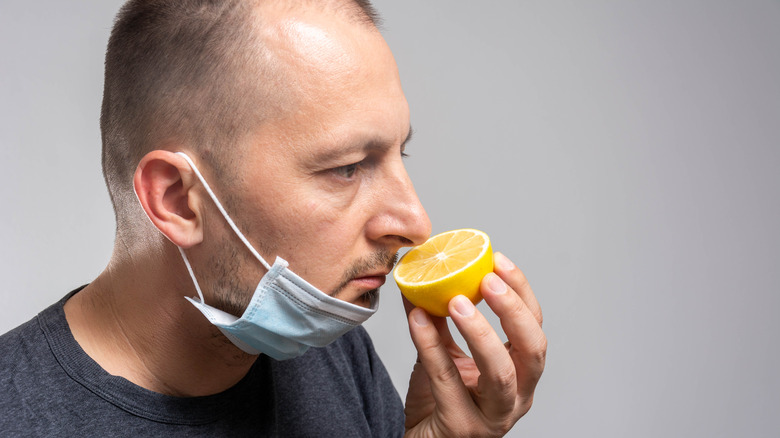 Man with covid smelling lemon