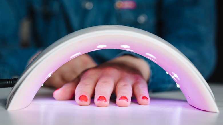 Manicured hands under UV light