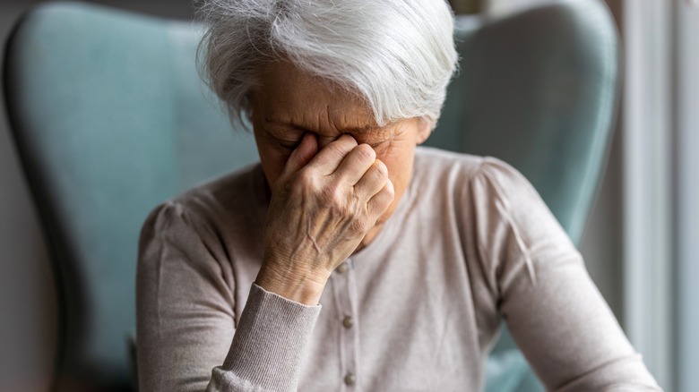 Woman holding head in pain