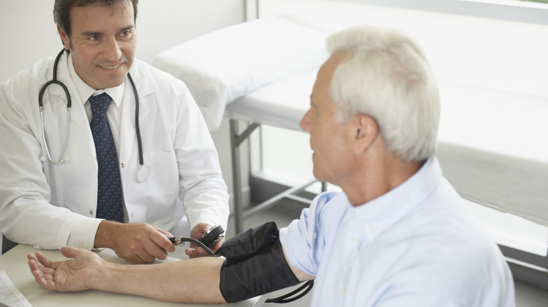 doctor checking patient's blood pressure