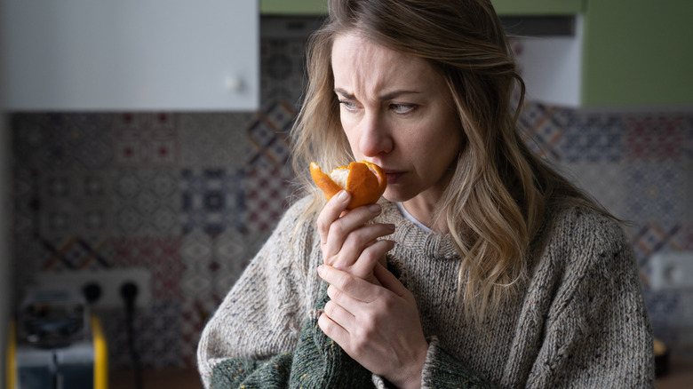 Woman sniffing peeled orange
